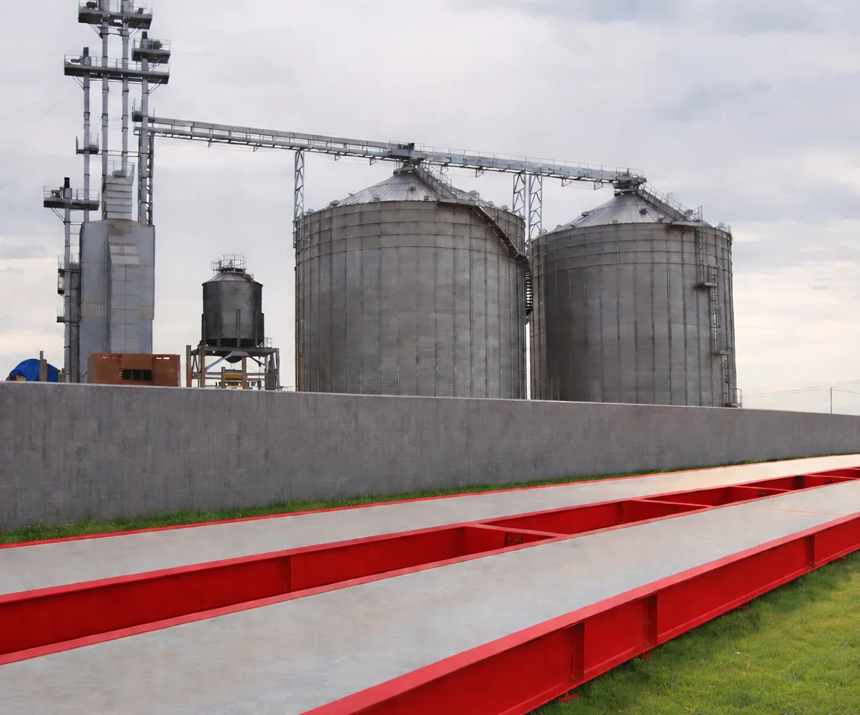 Plataforma de pesaje de concreto con estructura roja instalada junto a silos